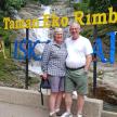 a man and woman standing in front of a waterfall
