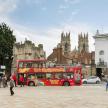 a red double decker bus parked in a city