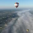 two hot air balloons are flying over a city