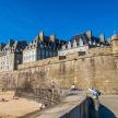 a large castle with people on the beach in front of it
