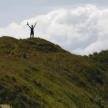 a man standing on top of a grassy hill