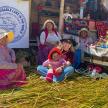 a group of women with a baby sitting on hay
