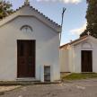 a small white chapel with two doors in a parking lot