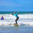 a woman is standing on a surfboard in the ocean