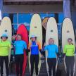 a group of people standing in front of surfboards