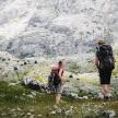 two people with backpacks walking on a mountain
