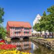 eine Brücke über einen Fluss in einer Stadt mit Blumen