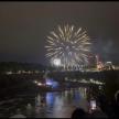 a firework display in the sky over a river at night