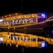 a boat with lights on the water at night