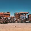 an old rusty train sitting in the desert