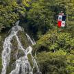 a man standing on a lift in front of a waterfall