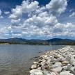 a group of rocks on the shore of a lake