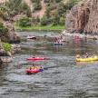 a group of people rafting down a river in canoes