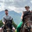 a man and a woman sitting on a horse