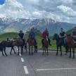 a group of people riding horses on the road