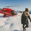 a woman walking in the snow next to a helicopter