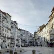 a city street with buildings and tables and people