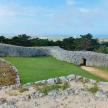 a stone wall on top of a hill with grass