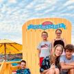 a group of children posing in front of a surfboard