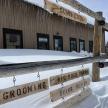 a wooden fence in the snow in front of a building