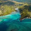 an aerial view of a beach with blue water