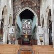 a large church with wooden pews and a large window