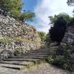 a stone retaining wall with stairs next to a stone wall