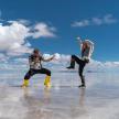 two men are standing in the water on a beach