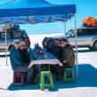 a group of people sitting at a table in the snow