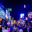 a crowd of people walking down a busy city street at night