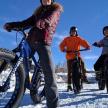 a group of three people on bikes in the snow
