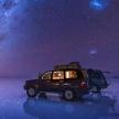 a car parked in the water under a starry sky
