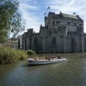 a group of people on a boat in front of a castle