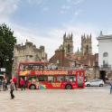 a red double decker bus parked in a city