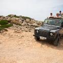 a group of people riding in a jeep on a dirt road