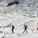 a group of people walking on a snow covered mountain
