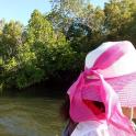 a girl in a pink hat looking at a river