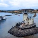 un barco y un faro en un río con un barco