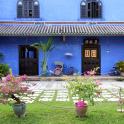 a blue house with flowers in front of it