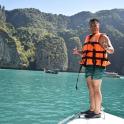 a man in an orange life vest standing on a boat in the water
