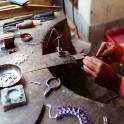 a person cutting a piece of metal on a table
