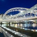 a large white bridge over water at night