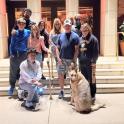 a group of people standing in front of a building with a dog