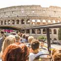 a group of people on a bus in front of the coliseum