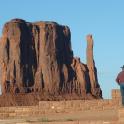 a man standing on a wall next to a rock formation
