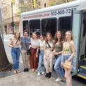 a group of women standing in front of a bus