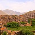 un pueblo en una colina con montañas al fondo
