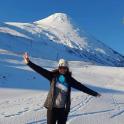 a woman standing in the snow in front of a mountain