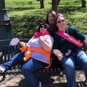 three women sitting on a bench in a park