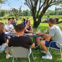 a group of people sitting at a table in the grass